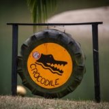 a yellow and black sign sitting on top of a grass covered field